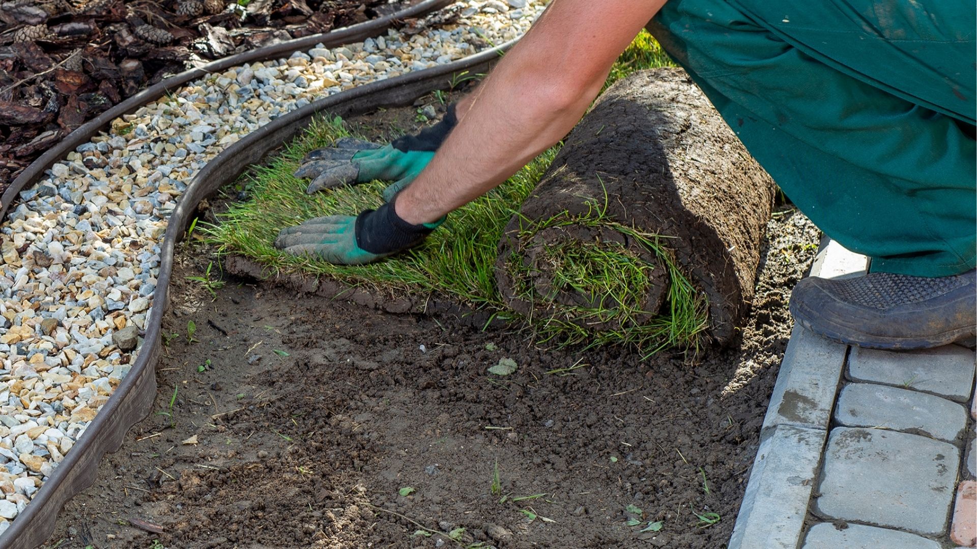 A person with a pair of gardening gloves on digging in the ground