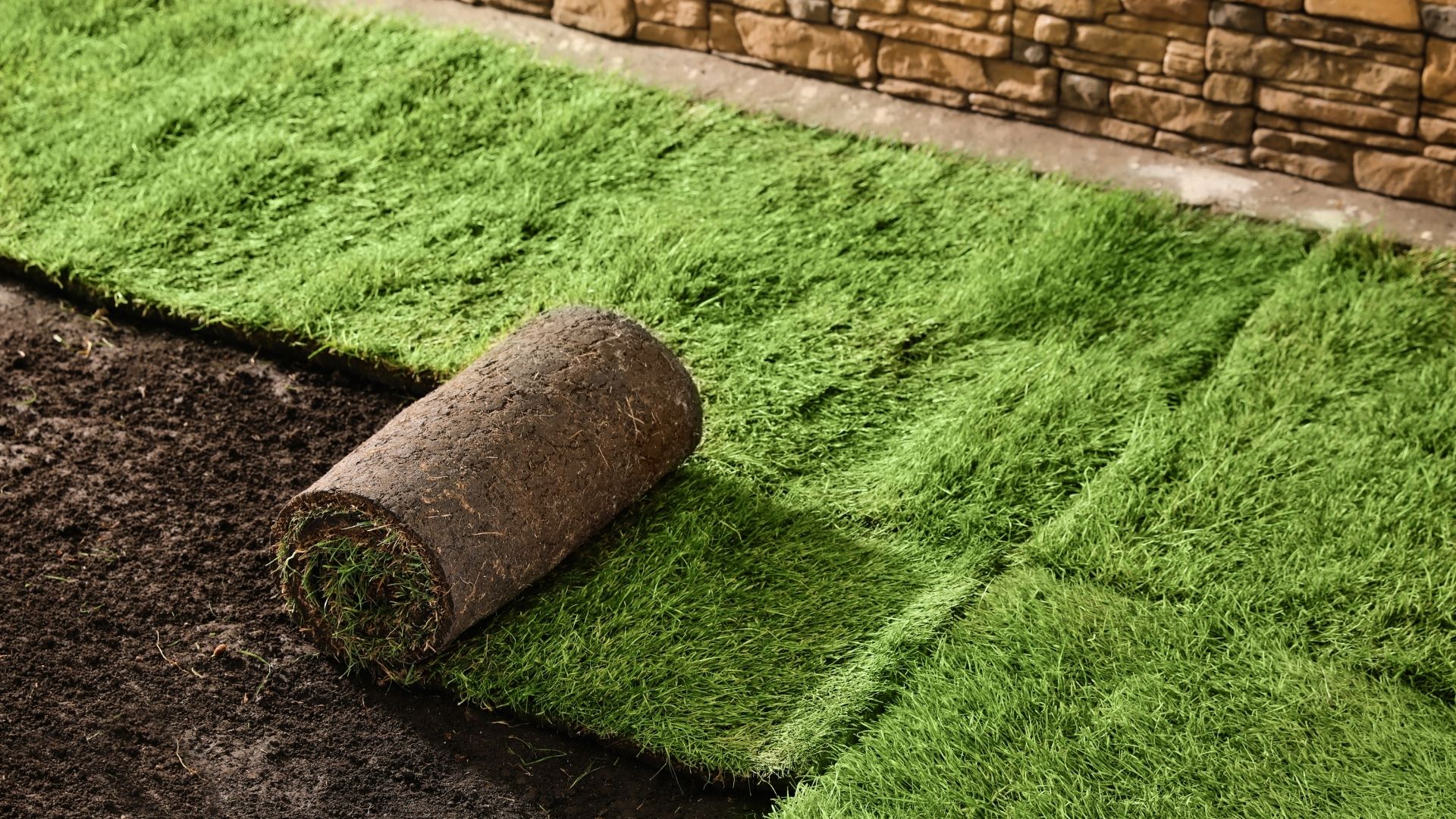 A roll of turf laying on top of a pile of dirt